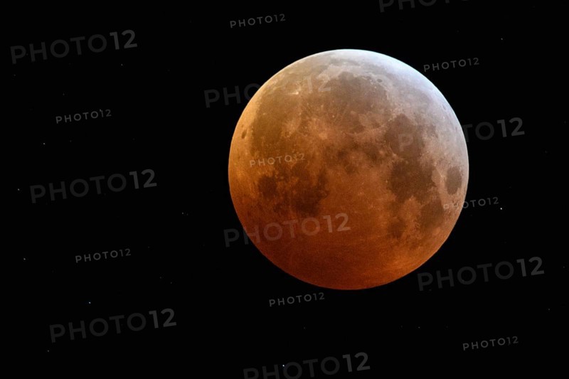 Complete solar eclipse, full moon, blood moon, super moon surrounded by sparkling stars, rare event in the night sky, on 21 January 2019 over North Rhine-Westphalia, Germany, Europe, Eclipse of the super moon, lunar eclipse, red supermoon, blood moon, red orange full moon with sparkling stars on January 21, 2019, Germany