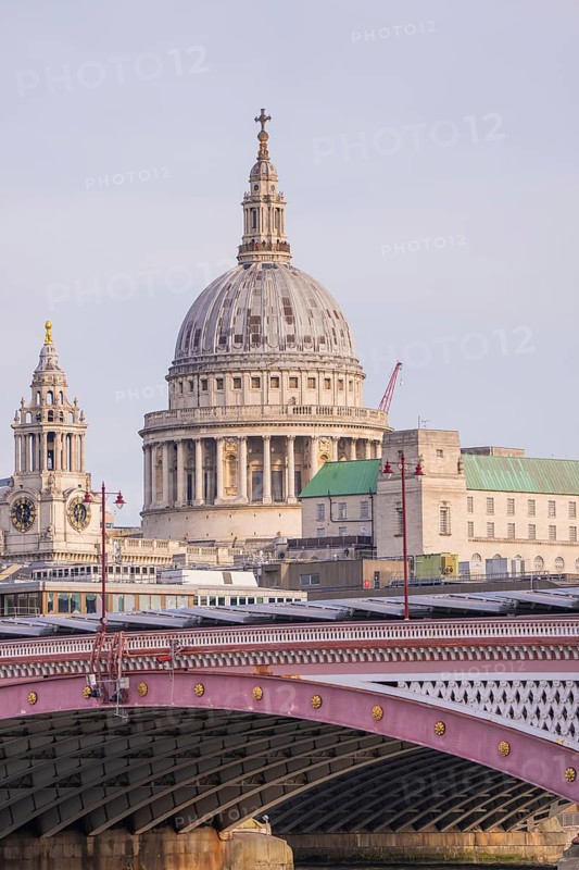 Bridge in front of a large cathedral with distinctive dome and towers, London, United Kingdom, World