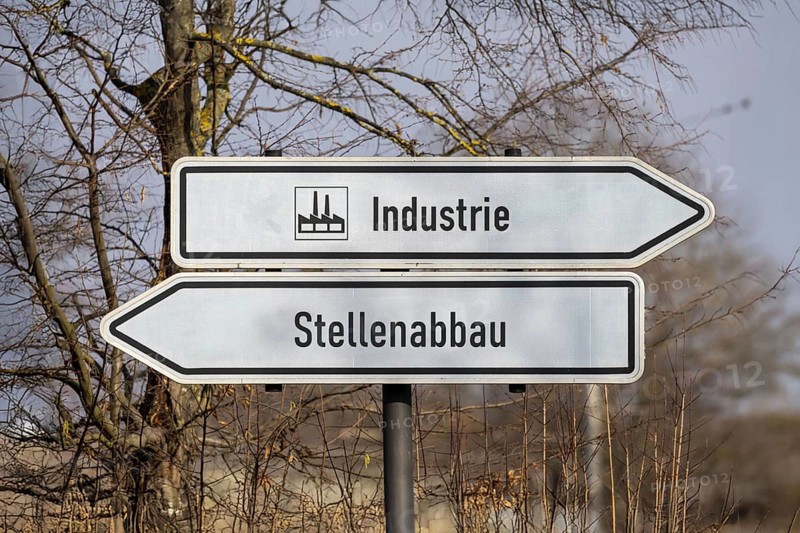 (photo montage) Directional arrows with the inscription INDUSTRY and JOB CUTS