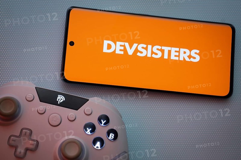 Dhaka, Bangladesh- 22 March 2025: Devsisters logo displayed on a smartphone surrounded by gaming accessories in an Blue background