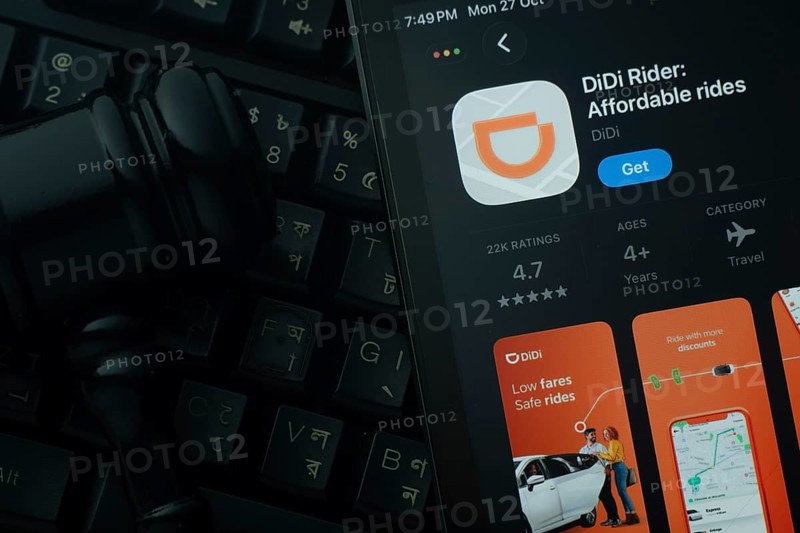 Dhaka, Bangladesh- 28 Oct 2025: An iPad displaying the DiDi Rider app against a judge's gavel and dark keyboard background