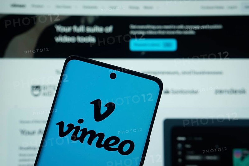 Dhaka, Bangladesh - 17 March 2025: The logo of the Vimeo is displayed on a smartphone screen, and the website is visible on a computer screen in the background