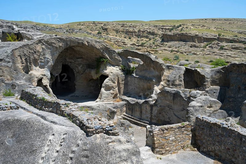 Rock formations with caves and ruins in a vast landscape under blue sky, Uplistsikhe cave town, Uplistsikhe, Inner Kartli region, Shida Kartli, Georgia