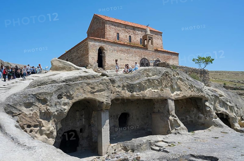 Historic church on a rock with caves and tourists on a clear day, 10th century princely church, Uplistsikhe cave town, Uplistsikhe, Inner Kartli region, Shida Kartli, Georgia