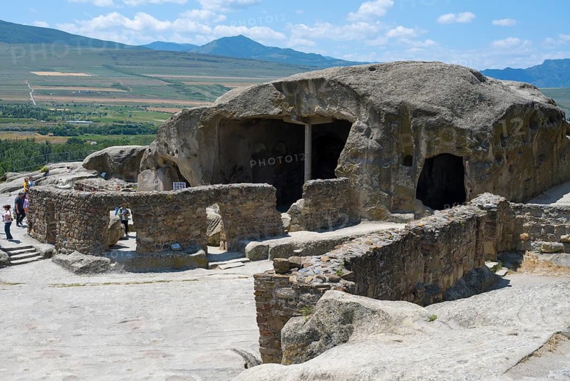 Ancient cave system with ruins in a vast landscape, visitors explore, Tamaris Darbasi, Tamaras Hall, Uplistsikhe cave town, Uplistsikhe, Inner Kartli region, Shida Kartli, Georgia