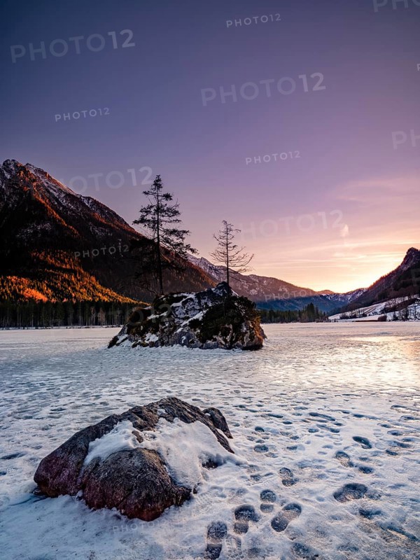 Rock island in frozen Hintersee, footprints on ice, evening light, Berchtesgaden National Park, Ramsau, Berchtesgadener Land, Upper Bavaria, Bavaria, Germany