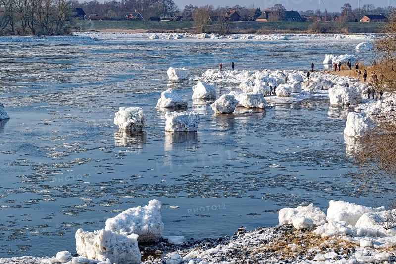 Many visitors look at the icebergs on the water of the Elbe and on the banks of the Elbe Island near Geesthacht on a cold winter day. Geesthacht, Schleswig-Holstein, Germany