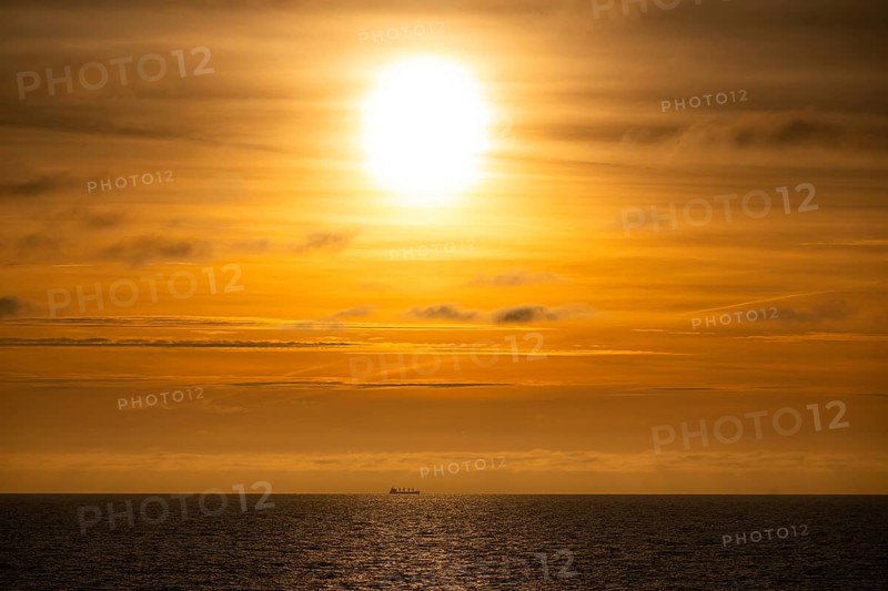 Silhouette, cargo ship on the horizon, sunset, Baltic Sea
