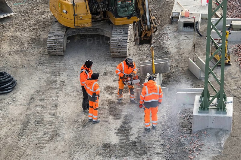 Workers wearing safety clothing use cutters near excavators on construction site, Untertürkheim parking lot, Stuttgart, Baden-Württemberg, Germany