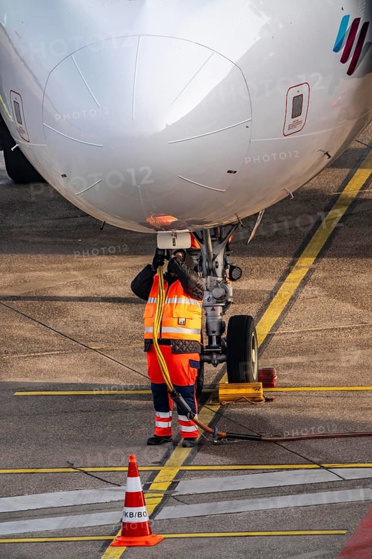 Ground crew installs ground power, power supply for the aircraft after stopping at the parking position, at the terminal, gate, at the Cologne/Bonn airport passenger bridge, CGN, North Rhine-Westphalia, Germany