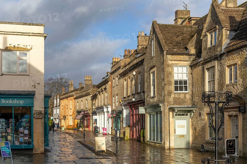 Wet pavements after rain in pedestrianised High Street are of town centre of Corsham Wiltshire, England, UK - quiet, few people