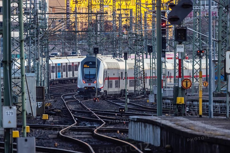 InterCity IC to Zurich leaving Stuttgart Central Station in the morning. Rail signals and overhead lines in early morning light. Stuttgart, Baden-Württemberg, Germany