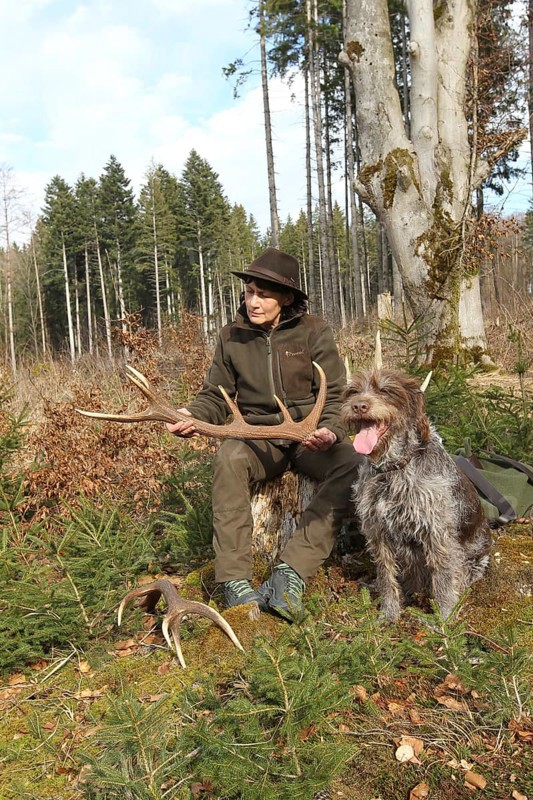 Huntress with a deer (Cervus elaphus) hunting dog Griffon at her side, Allgäu, Bavaria, Germany, Allgäu, Bavaria, Germany