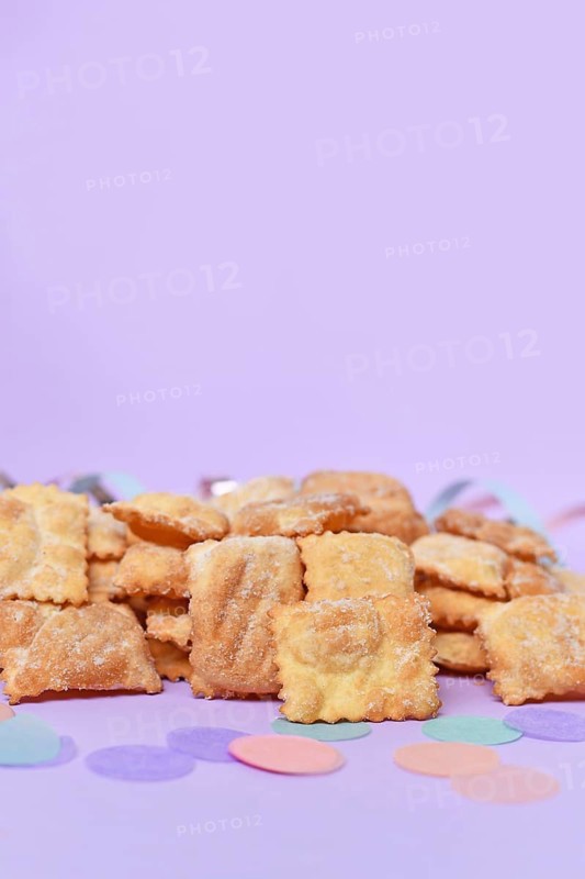 Rhenish pastries called 'Mutzen pastries or Muzenblätter' with powdered sugar on festive background. Traditional German carnival and Fasching fried pastry