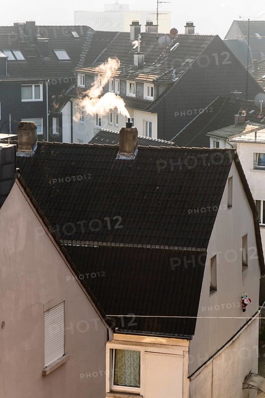 Smoke plume from a chimney over densely built residential area in the evening light, wintry city scene, Wuppertal, Germany
