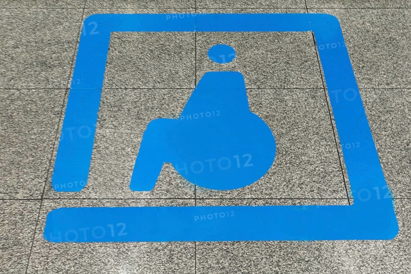 Sign for disabled people in front of a baggage carousel at the airport, Krakow, Poland