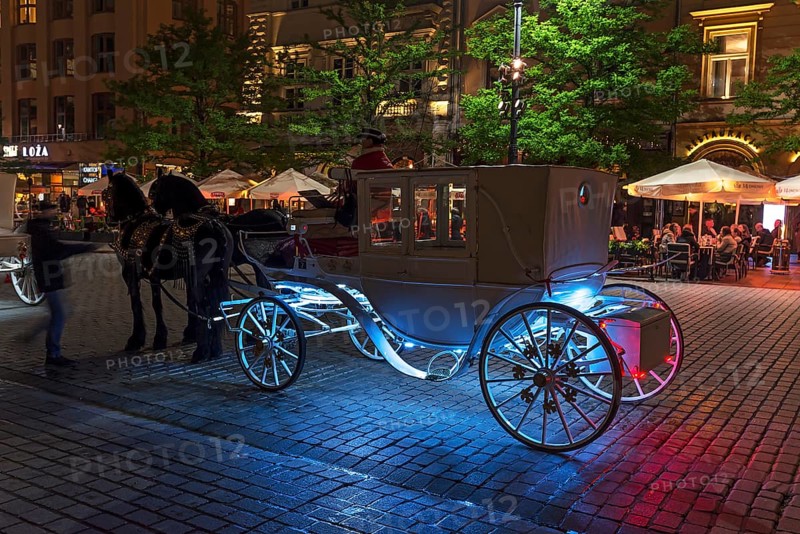 Waiting horse-drawn carriage at the market square at night, Krakow, Poland