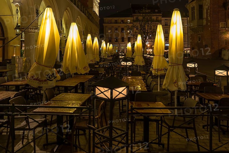 Illuminated umbrellas in a restaurant on the market square at night, Krakow, Poland