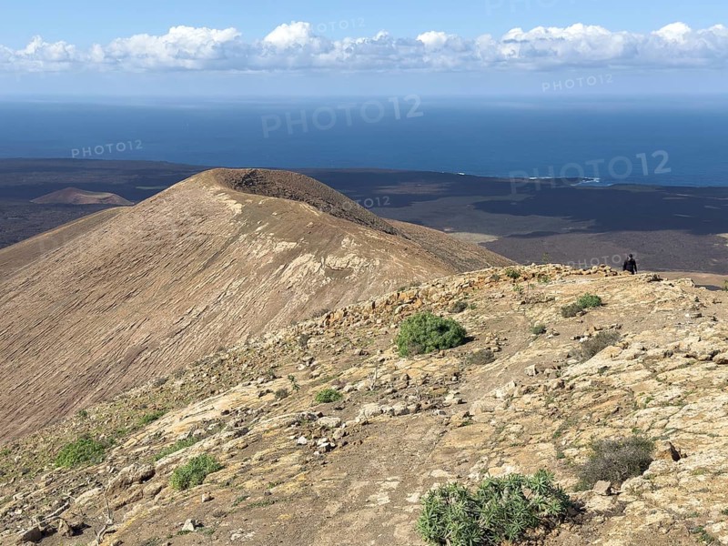 View from Caldera Blanca volcano against blue sky with white clouds, Mancha Blanca, Lanzarote, Canary Islands, Spain