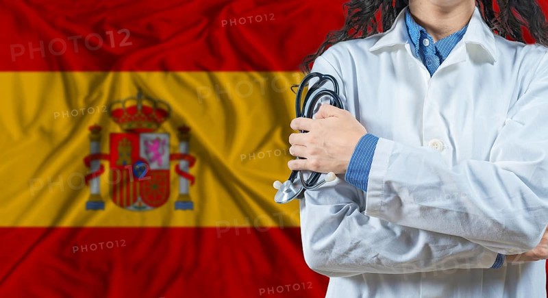 Healthcare professional with Spain flag background. Professional doctor holding stethoscope on Spain flag background