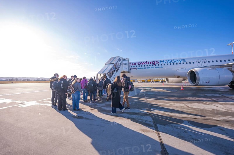 Group of travelers boards Eurowings aircraft in sunny weather, Stuttgart Airport, Germany