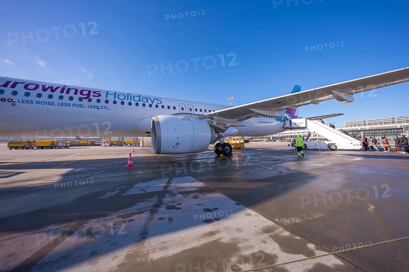 A Eurowings plane at an airport with people boarding a flight of stairs, Stuttgart Airport, Germany