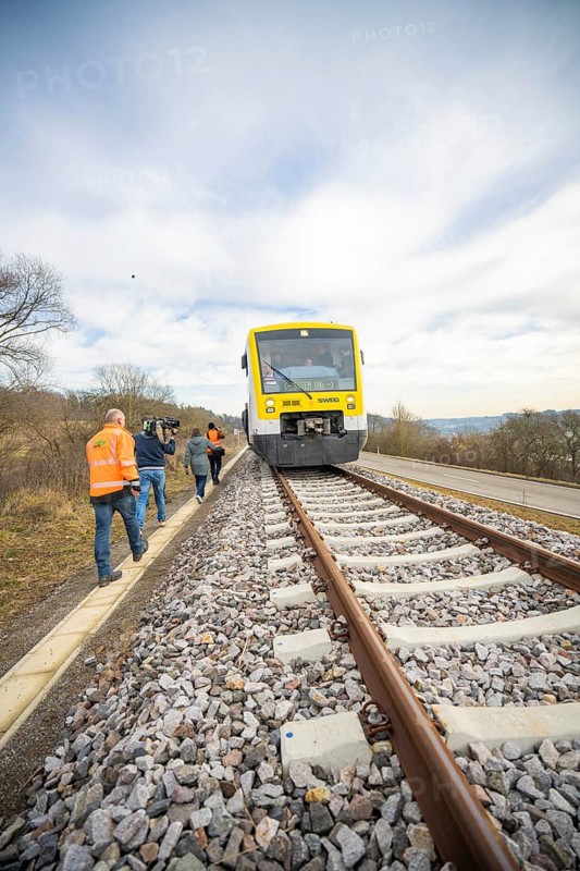 A train on rails with photographers in orange vests in a natural environment, acceptance of the Hermann Hessebahn, Calw, Germany