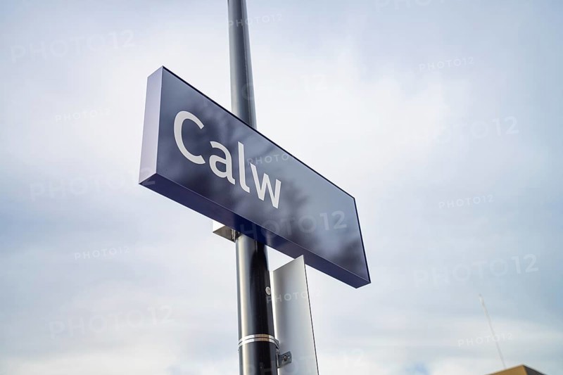 A simple sign with 'Calw' in blue against a cloudy sky, Abfahrt der Hermann Hessebahn, Calw, Germany