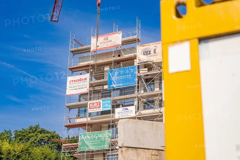 Multi-storey scaffolding structure with company logos on a sunny construction site, carpentry, new building, Stuttgart, Germany