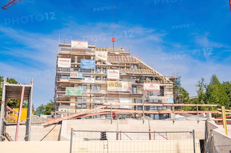 Building under construction with scaffolding and advertising banners under blue sky, carpentry, new building, Stuttgart, Germany