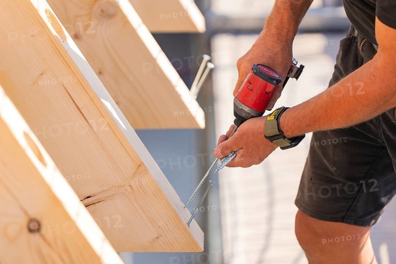 Close-up of a worker screwing a board with a drill, carpentry, new building, Stuttgart, Germany