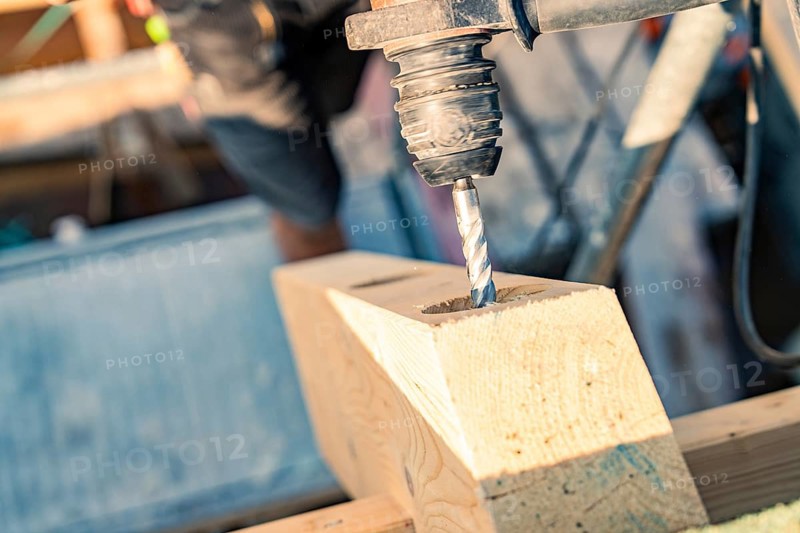 Detailed view of a drill drilling a hole in wood on a construction site, carpentry, new building, Stuttgart, Germany
