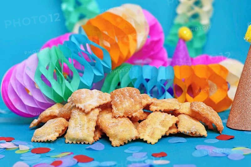 Rhenish pastries called 'Mutzen pastries or Muzenblätter' with powdered sugar on festive background. Traditional German carnival and Fasching fried pastry