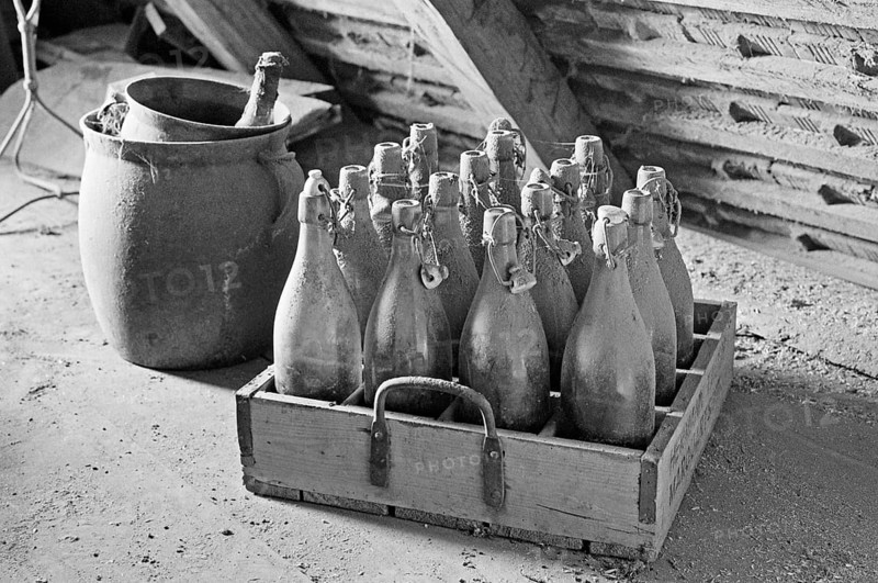Old wooden beer crate with beer bottles from the 1940s in the attic, on a former Franconian farm, black and white, Bavaria, Germany
