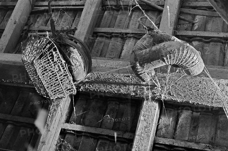 Dusty shopping basket and chimney pipes on the grain and hayloft, on a former Franconian farm, black and white, Bavaria, Germany