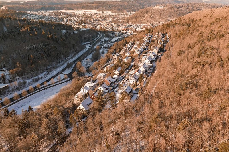 Snowy winter landscape of a village on the edge of a hill, surrounded by forest, Nagold, Calw district, Black Forest, Germany