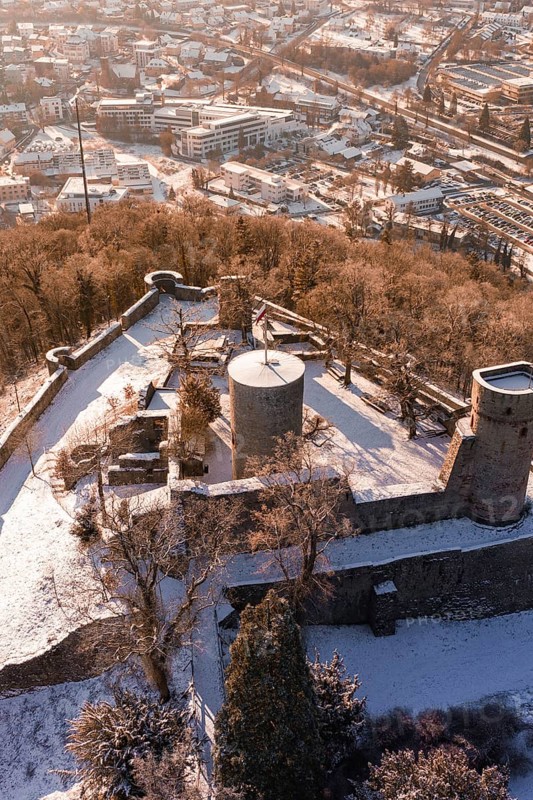 Snowy castle with towers and walls, surrounded by forest and city in the background, Nagold, Calw district, Black Forest, Germany