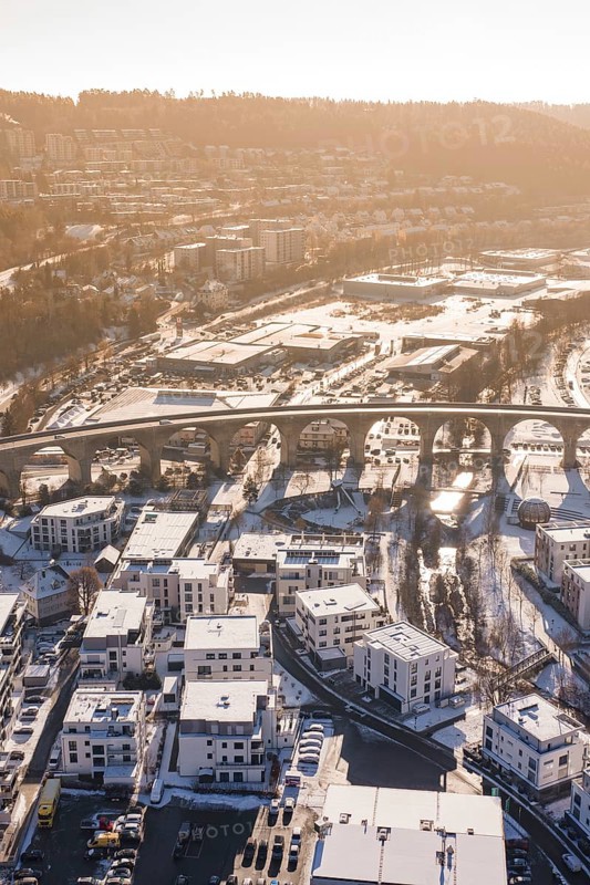 Aerial view of a viaduct over a snowy town surrounded by hills in morning light, Nagold, Calw district, Black Forest, Germany