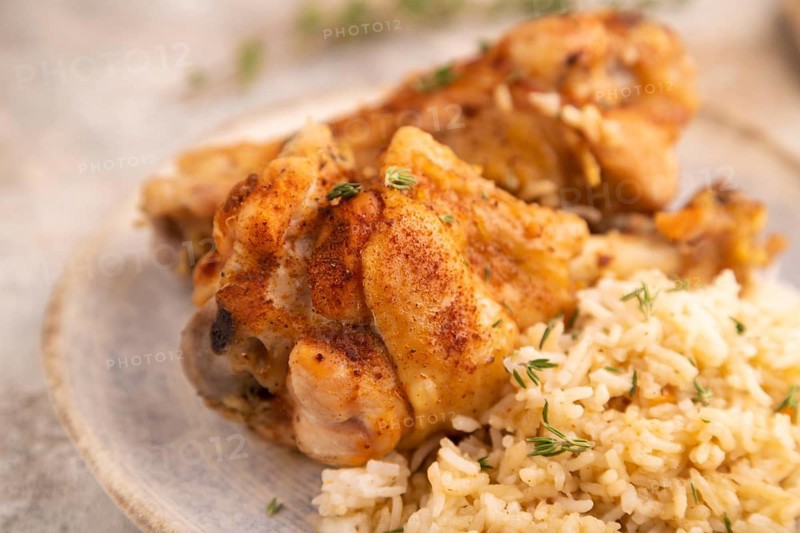 Fried Turkey Wing with spices and rice on brown concrete background and linen textile. side view, close up, selective focus