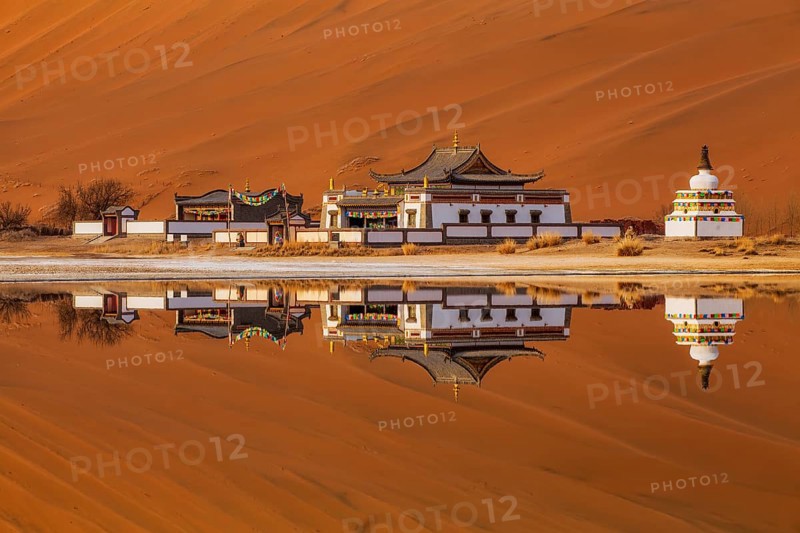 Reflection of Badain Jaran Temple by the shore of a lake, Tibetan-Buddhist temple, Badain Jaran Desert, Inner Mongolia Autonomous Region, China, Asia