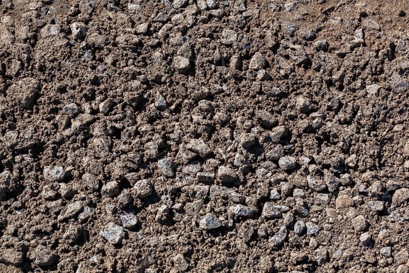 Close-up of sand mixed with grey crushed stone aggregate used to form a bed for constructing roads and driveways on, Quebec, Canada