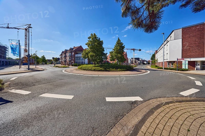 Roundabout, sidewalk, lantern, general architecture, commercial building, residential building, crane, advertising flags on flagpoles, roads, meadow, branch, trees, blue sky, cirrus clouds, roundabout between Butenwall, Im Piepershagen and Burloer Straße, Borken, Münsterland, Borken district, North Rhine-Westphalia, Germany