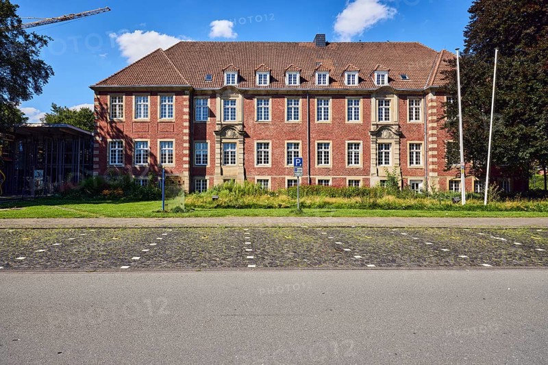 Town hall, brick buildings, flagpoles, façade with windows, dormers, parking boxes, sidewalk, asphalt road, paving stones, meadow, trees, blue sky, cumulus clouds, Im Piepershagen, Borken, Münsterland, Borken district, North Rhine-Westphalia, Germany