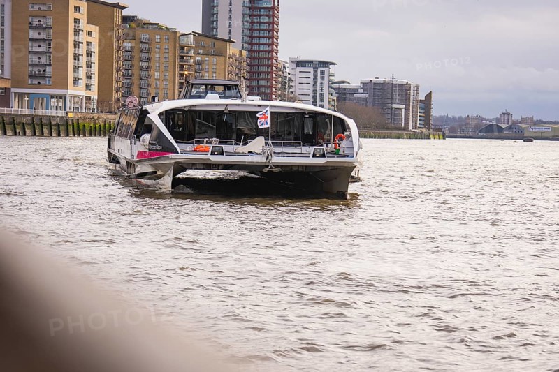 A river with tall modern buildings on its banks, with a ship in the foreground, London, England, Great Britain