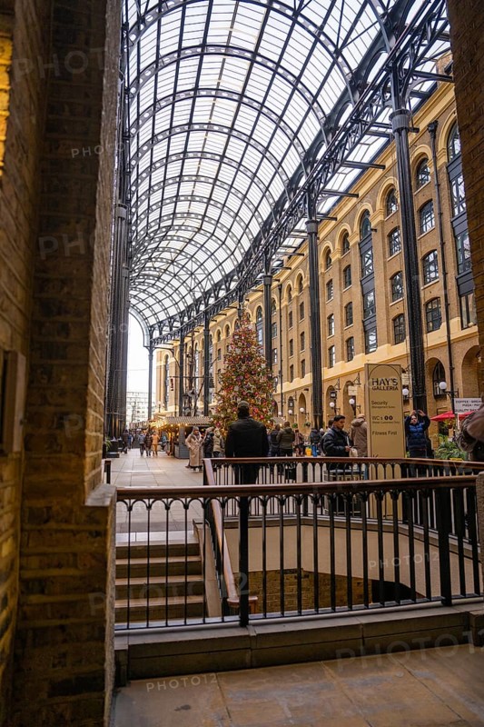 A shopping mall interior with a big Christmas tree and lots of people, London, United Kingdom