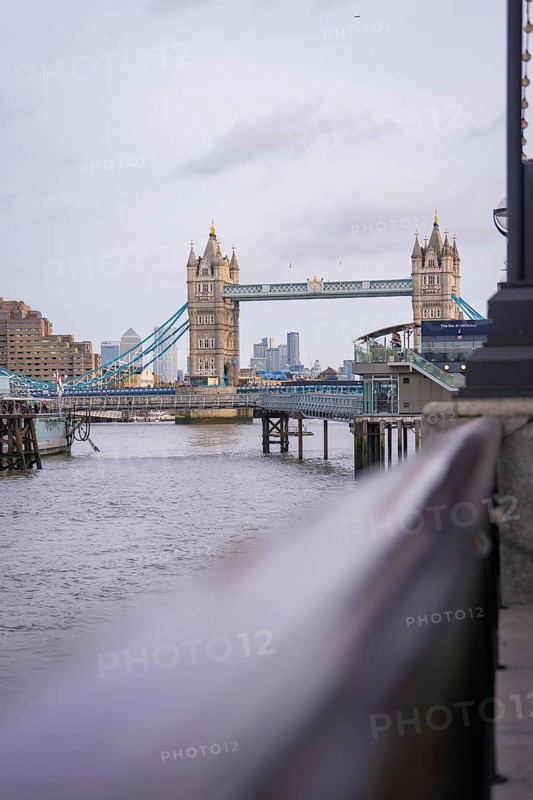Historic bridge with towers over a river with an urban skyline in the background, Tower Bridge, London, United Kingdom