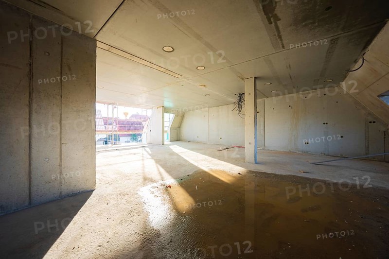 Unfinished room with concrete walls, light and shadow on the floor, carpentry, renovation, roof extension, Stuttgart, Germany