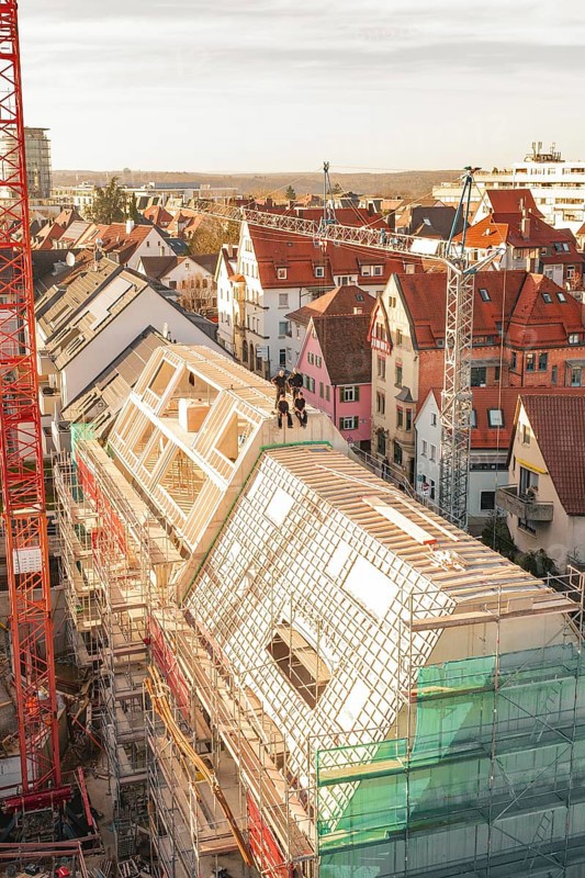 Urban construction on a roof with a crane and surrounding houses, carpentry, renovation, roof extension, Stuttgart, Germany