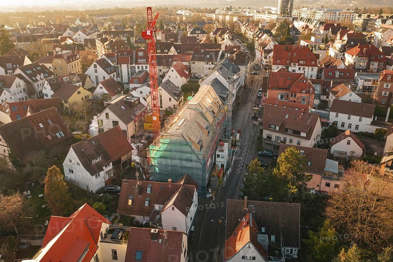 Urban scene with a construction site and surrounding residential buildings from a bird's eye view, carpentry, renovation, roof extension, Stuttgart, Germany