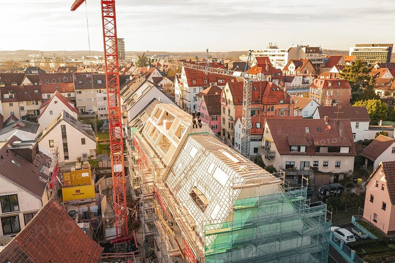 Construction site on a roof in the city with crane and surrounding houses, carpentry, renovation, roof extension, Stuttgart, Germany